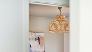 A bedroom with a bed, a woven pendant light, and a piece of abstract art on the wall. - Private Guest House with Full Kitchen, 30 minutes to L.A. & Beach (Thousand Oaks)