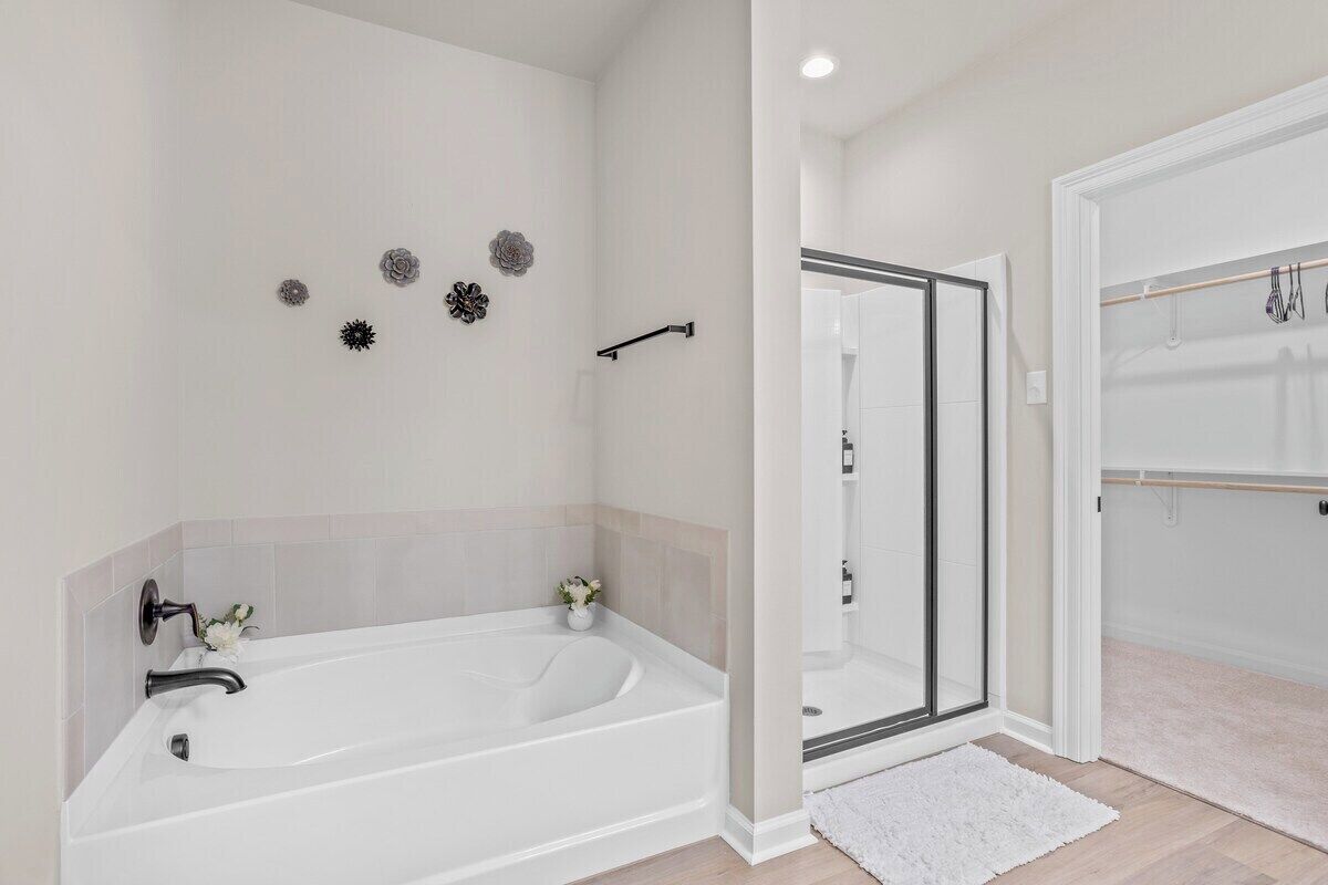 A modern bathroom with a freestanding bathtub, a glass shower enclosure, and a white shower curtain.