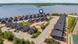 A residential area with houses, a parking lot, and a lake. - Lake View Getaway with Hot Tub, Arcade, Indoor Community Pool & Free Silver Dollar Tickets (Hollister)