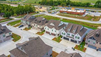 A residential area with modern houses, a commercial building, and a road.