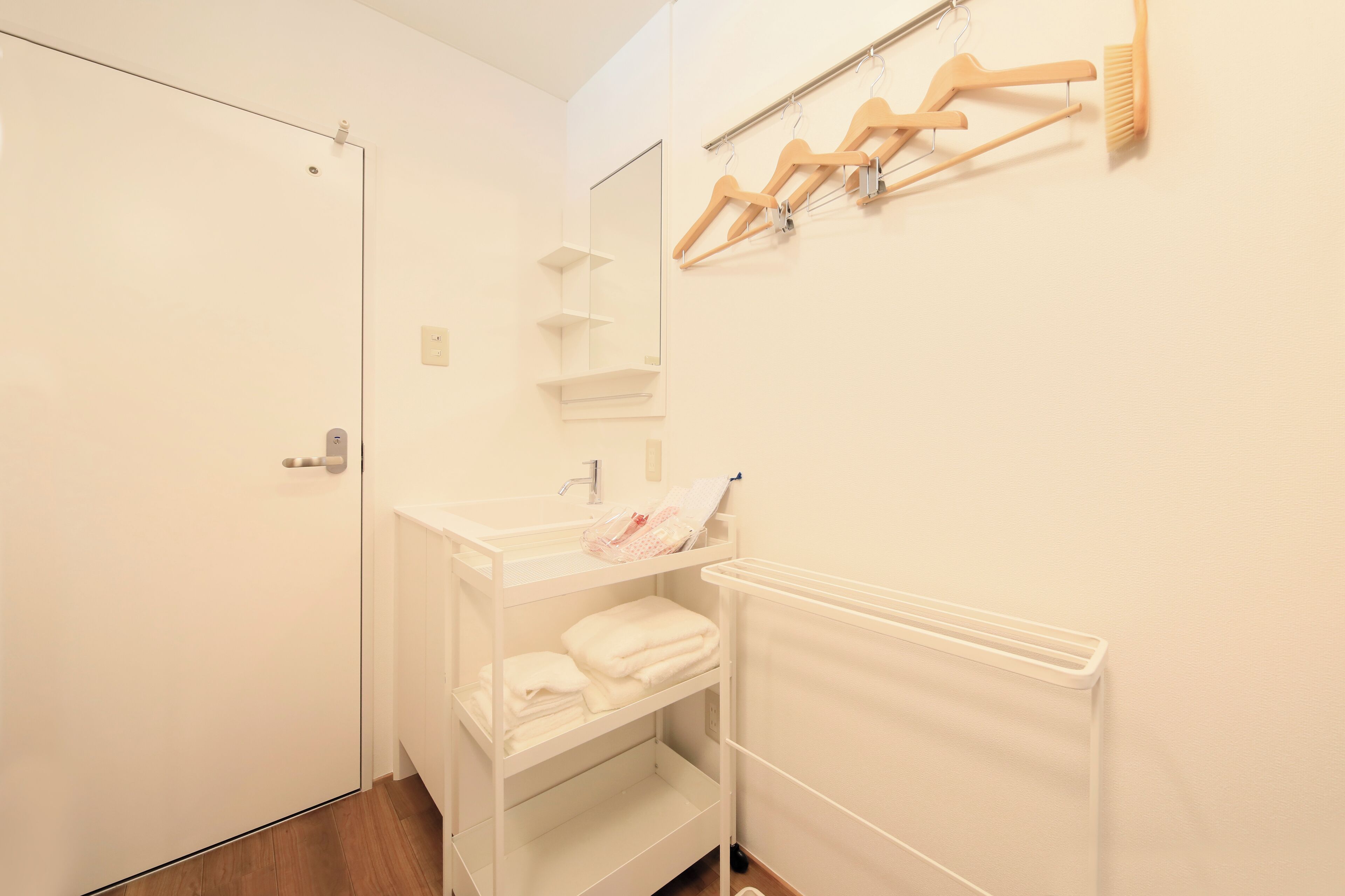 A small, clean bathroom with a white sink, a mirror, and a towel rack.