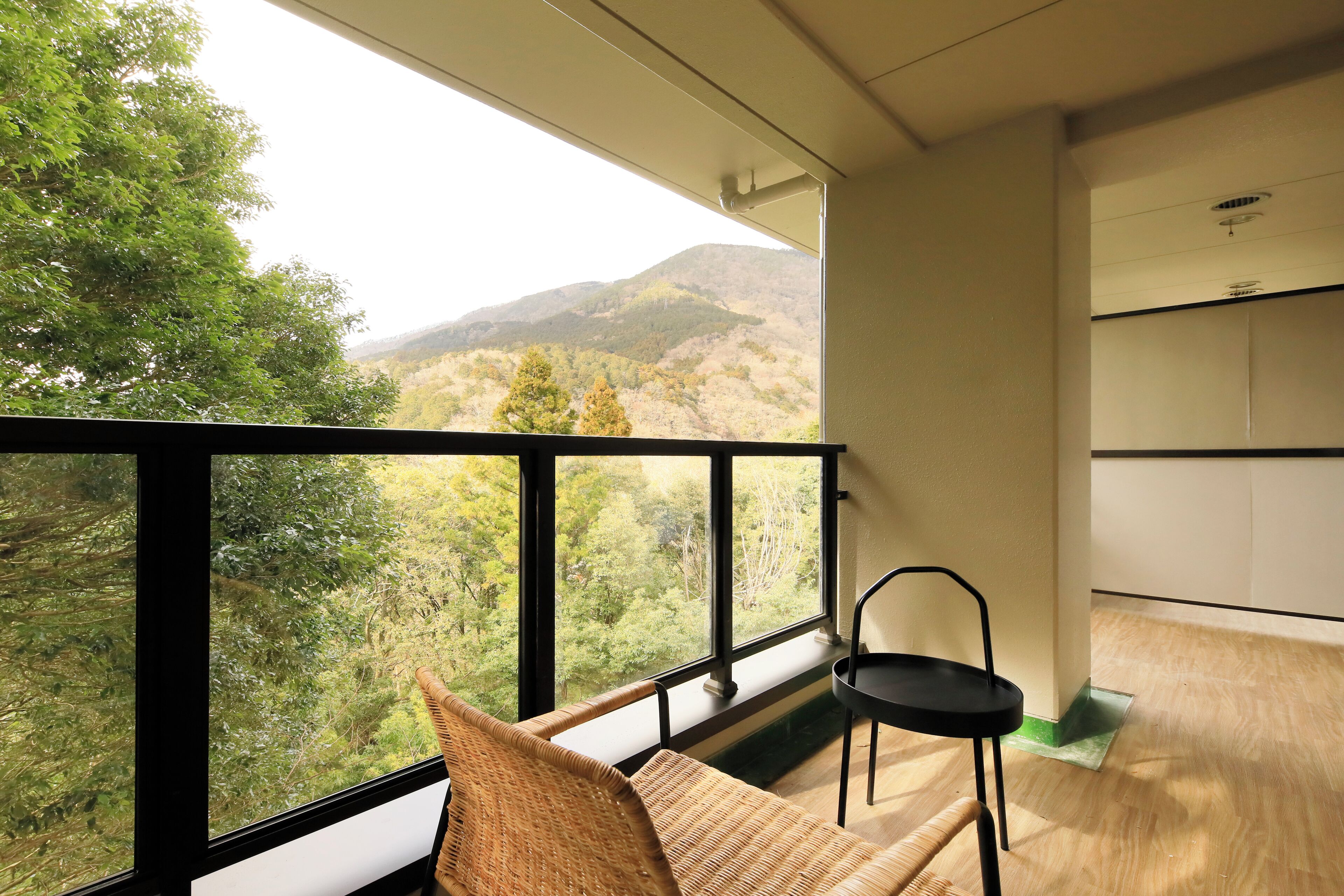 A balcony with a view of a forested mountain range.
