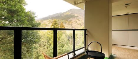 A balcony with a view of a forested mountain range.