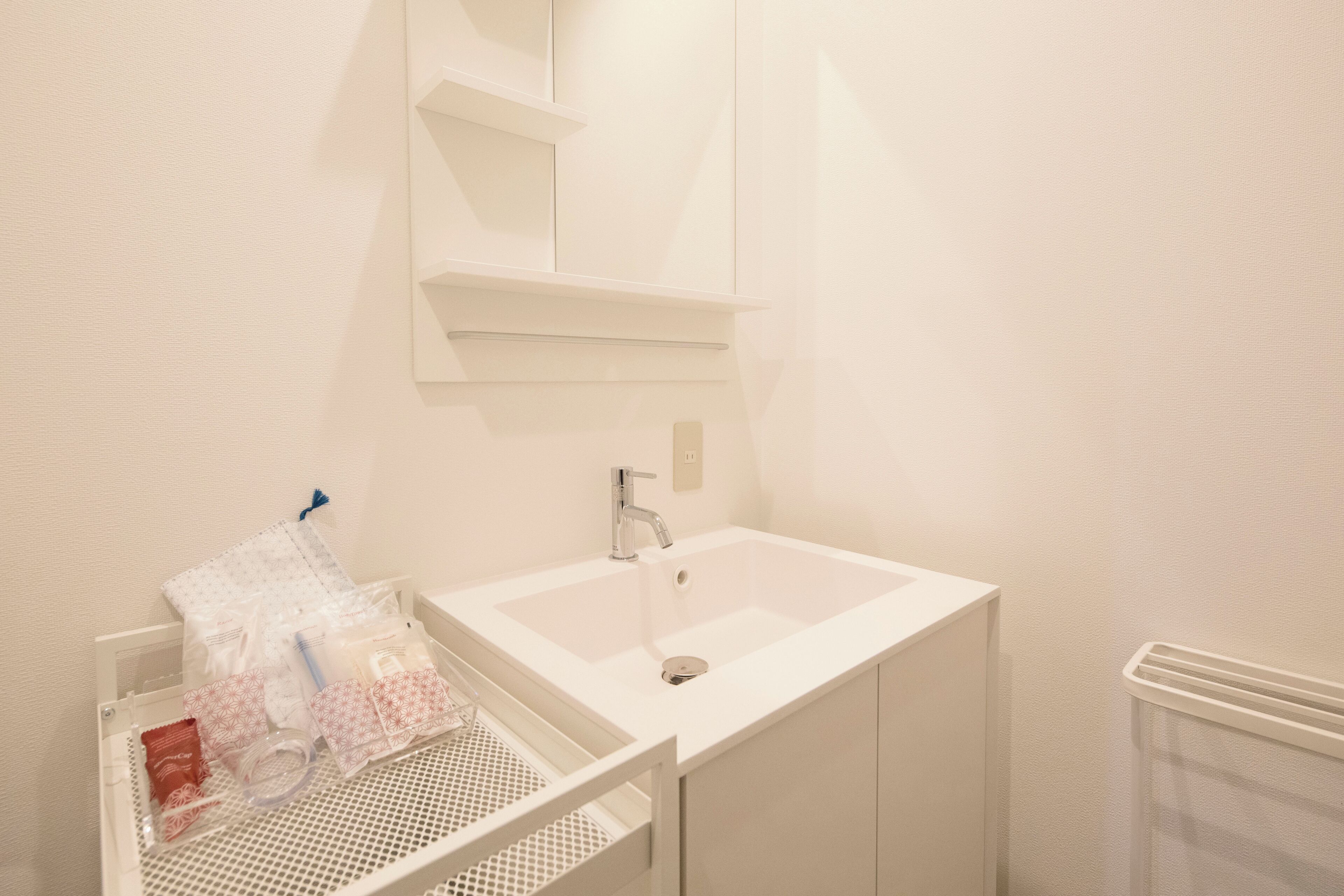 A bathroom with a white sink, a mirror above it, and a towel rack.