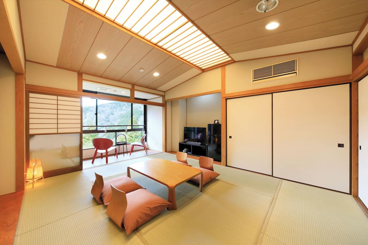 A traditional Japanese room with tatami flooring, a low wooden table, and a sliding door.
