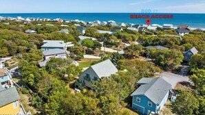 A residential area with houses surrounded by greenery, a clear view of the ocean, and a sign indicating beach access 800 ft away. - Short walk to ocean and sound! NEW HOT TUB, FREE use of golf cart! Several decks (Emerald Isle)