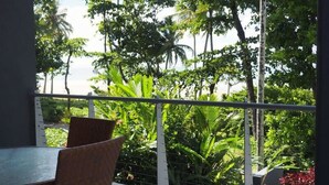 A balcony with a view of lush greenery and tall trees. - BHA 1 Beachfront Haven fullhouse (Mission Beach)