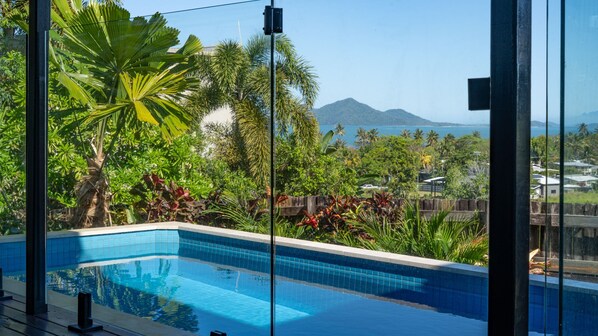 A swimming pool with a view of mountains and tropical vegetation.