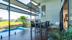 A modern outdoor deck with a pool, dining area, and a view of the surrounding landscape. - The Rise Dunk Island views and ocean breeze (Mission Beach)