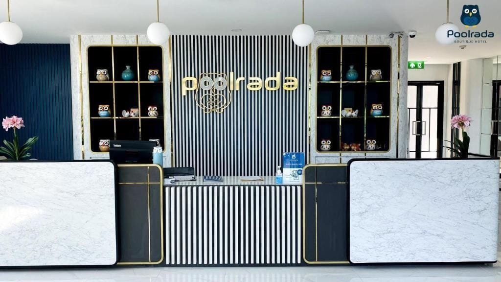 Una recepción con estampado de rayas verticales y un cartel que dice 'Poolrada Boutique Hotel'.