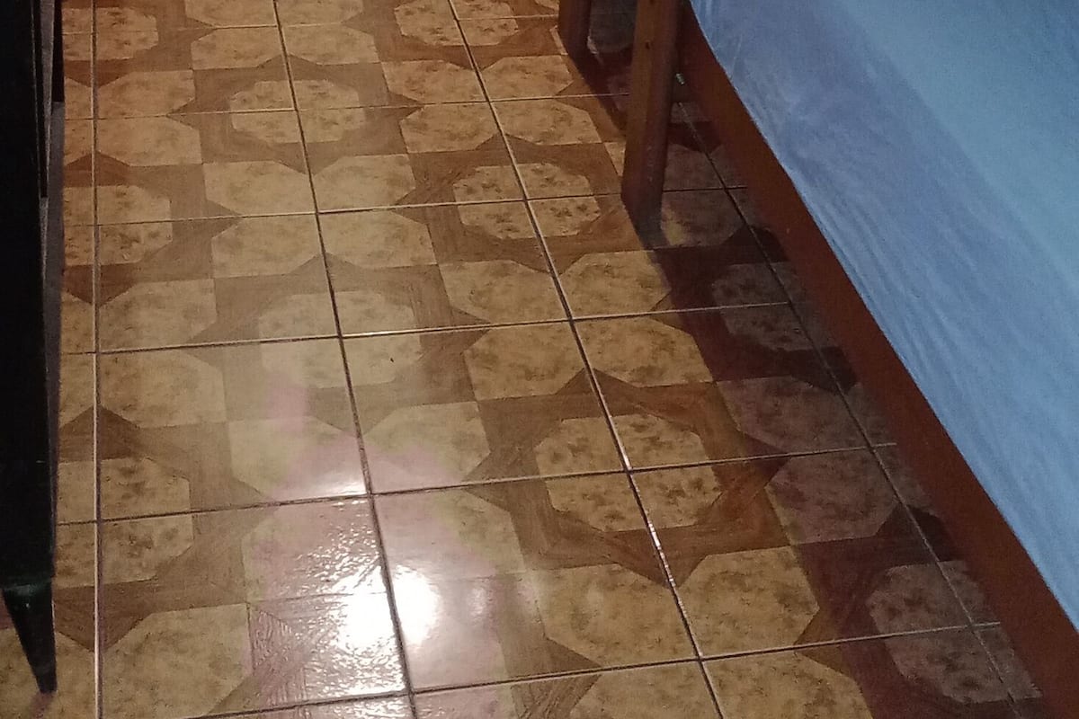 Ein Zimmer mit drei Etagenbetten, einem violetten Vorhang und einem gefliesten Boden.