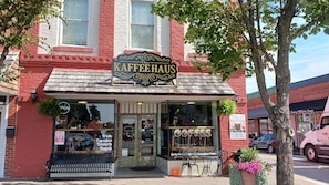 A coffee shop named 'Das Kaffee Haus' with a rustic exterior, a wooden sign, and a storefront with large windows.