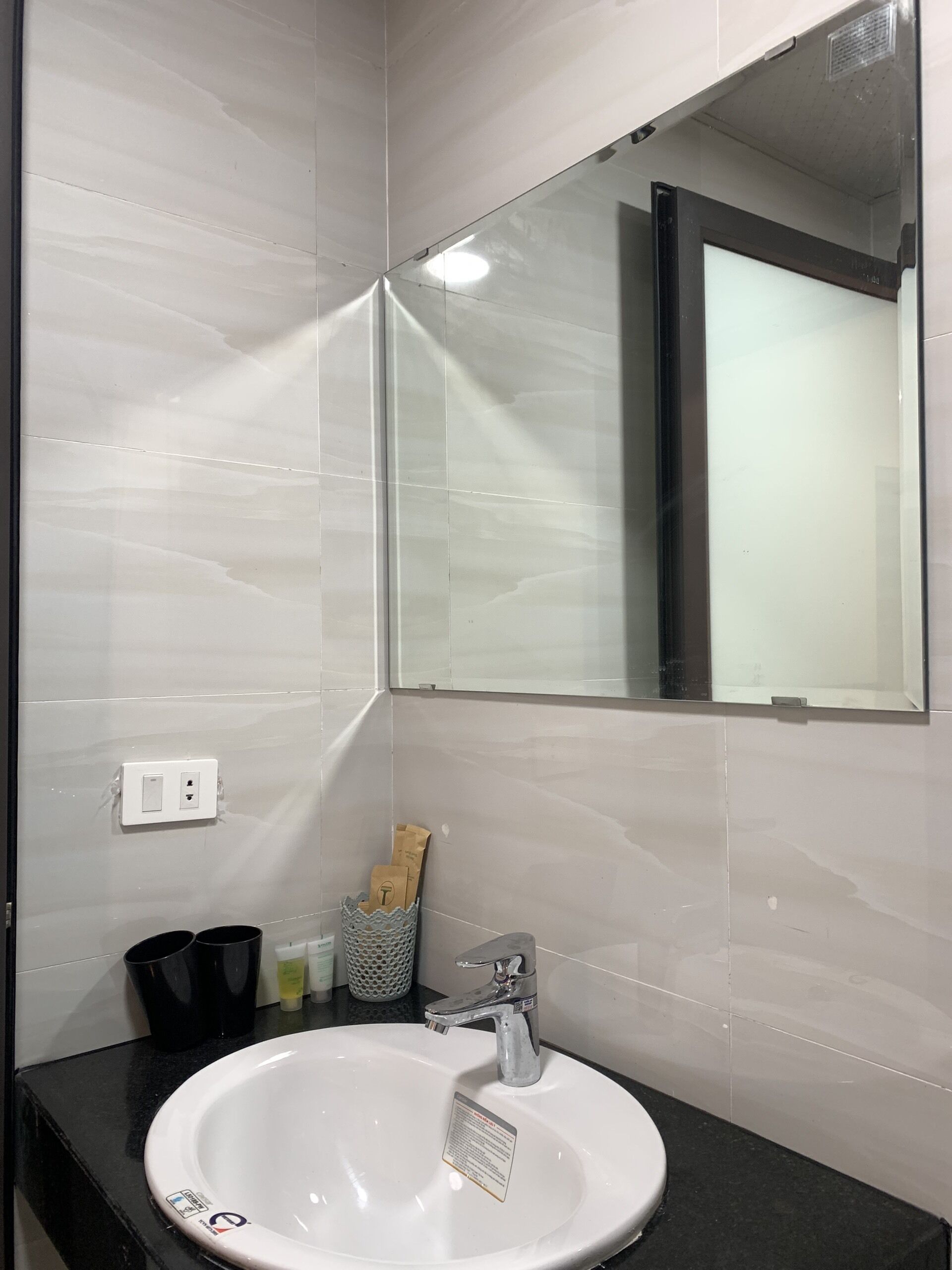Une salle de bain avec un lavabo blanc, un miroir et un porte-serviettes.