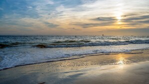 Una spiaggia con onde e un tramonto.