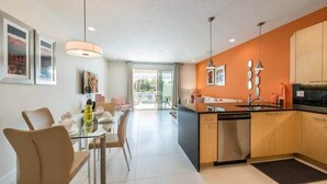 Una cocina moderna con una isla central, armarios de madera e iluminación colgante.