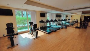A gym with treadmills, stationary bikes, and exercise equipment. - NEW Direct Golf View Sport City 2BD (Dubai)