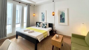 A modern hotel room with a bed, bedside table, and a green armchair. - LOTUS SERENITY Hostel (Siem Reap)