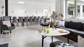 Un interior moderno con comedor, sofás y una mesa de centro.