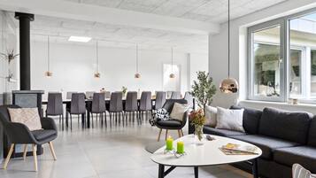 Un intérieur moderne comprenant un coin repas, des canapés et une table basse.