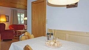 A dining area with a wooden table, chairs, and a lamp. - Lieblingsplatz by Interhome (Flirsch)