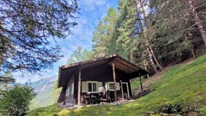 A rustic cabin with a sloped roof, wooden beams, and a porch area. - Lieblingsplatz by Interhome (Flirsch)