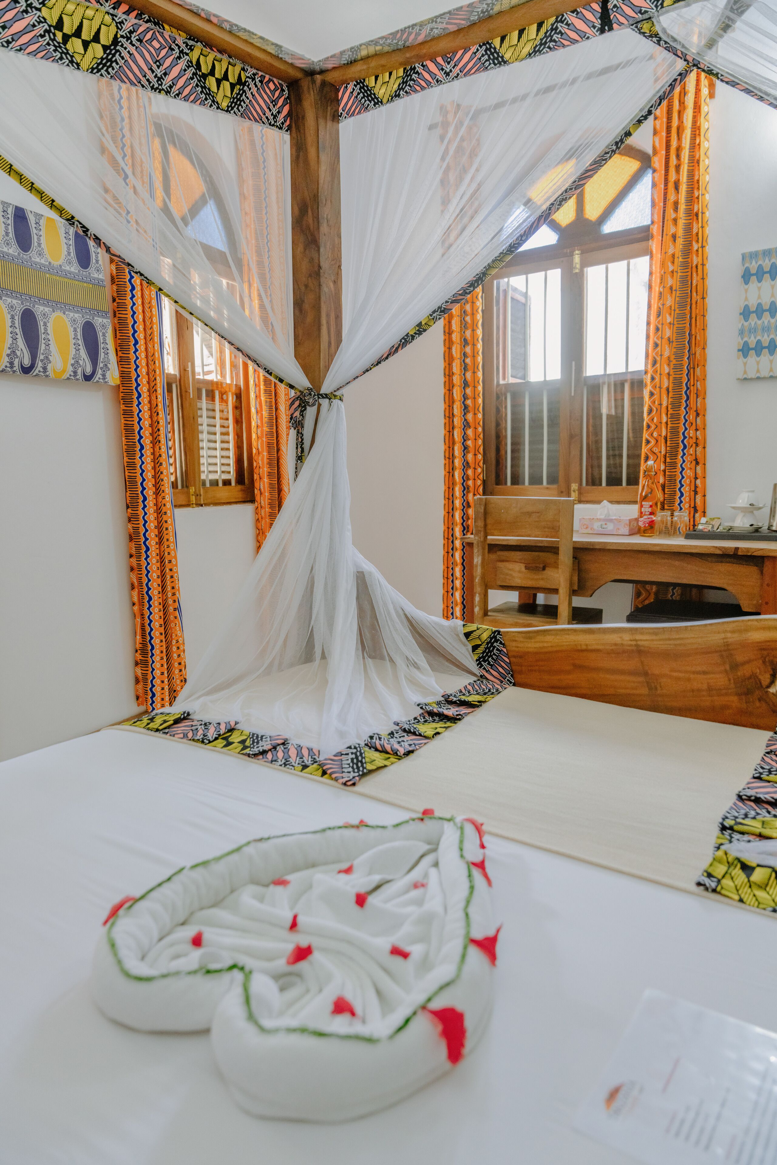A room with a bed, a wooden desk, and a chair.