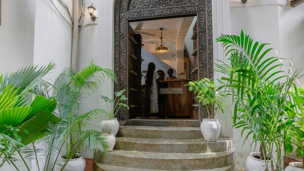 A staircase leading to a shop with a sign reading "Karibuni". - Shoki Shoki Hotel Stone Town (Zanzibar Town)