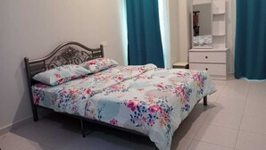 Un dormitorio con cama, mesita de noche, cómoda y espejo.