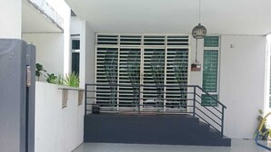 Una entrada moderna a un edificio con una escalera metálica que lleva a un área cubierta.
