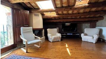 Een smart-tv, een open haard, boeken en een printer