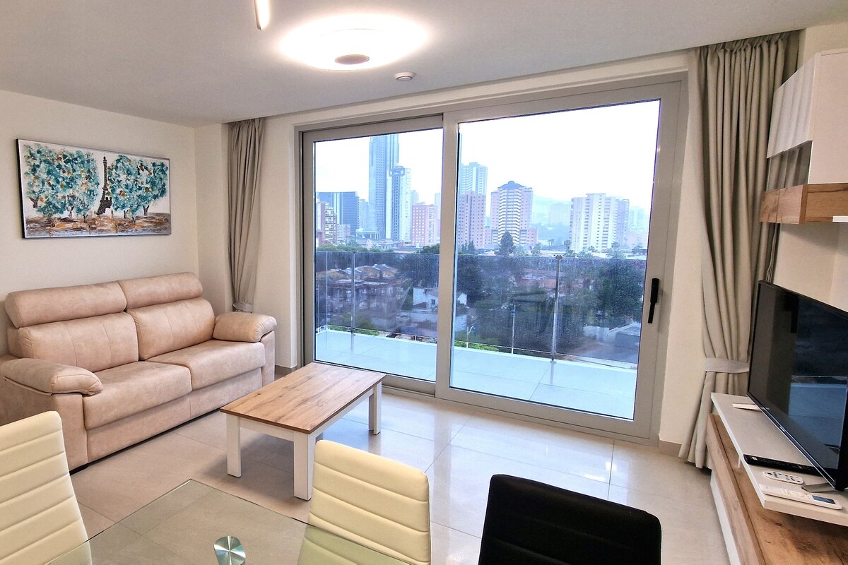 Una sala de estar moderna con un sofá, una mesita de centro y un televisor.