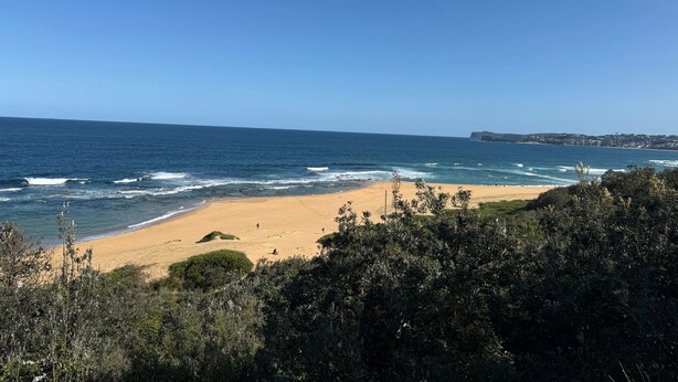 A beach with clear blue sky and ocean waves. - Cozy House in Forresters Beach - modern interiors  (Forresters Beach)