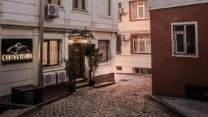 A building with multiple floors, air conditioning units, and a sign that reads "CARIBBEAN HOUSE". - Carvan Hotel (Istanbul)