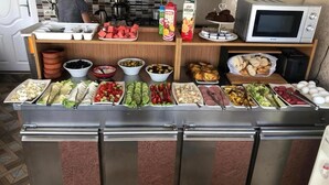 A buffet with various food items including fruits, vegetables, and bread. - Carvan Hotel (Istanbul)