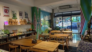 A restaurant interior with wooden tables and chairs, a buffet area with food items, and a mural on the wall. - Sun and Moon Splendor (Yuchi)