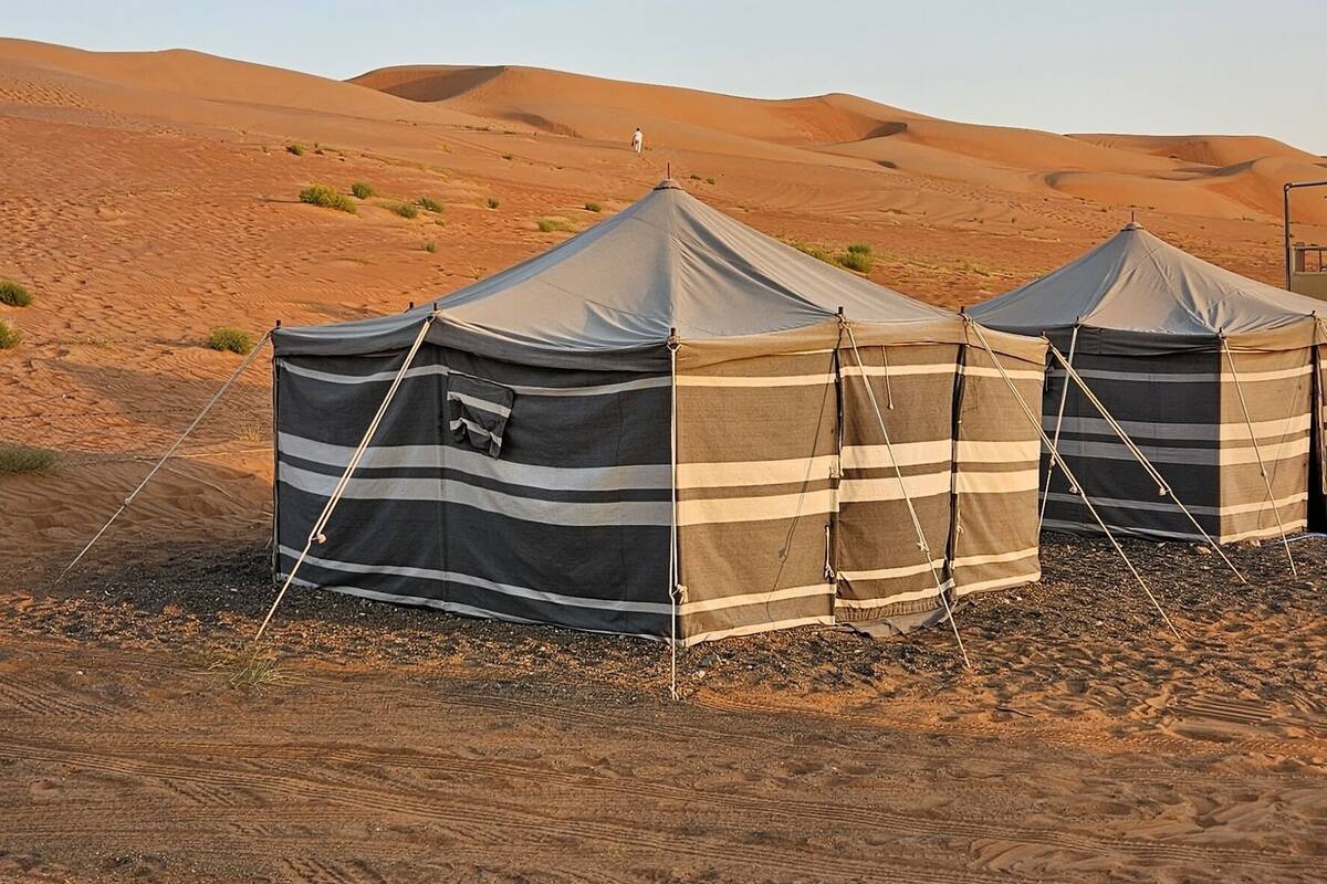 Three tents in a desert setting.