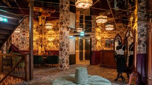 A lobby with a patterned carpet, a staircase, and a round seating area. - Charmante Skostredet Hôtel (Bergen)