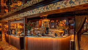 A bar area with a wooden counter, various bar tools, and decorative items. - Charmante Skostredet Hôtel (Bergen)
