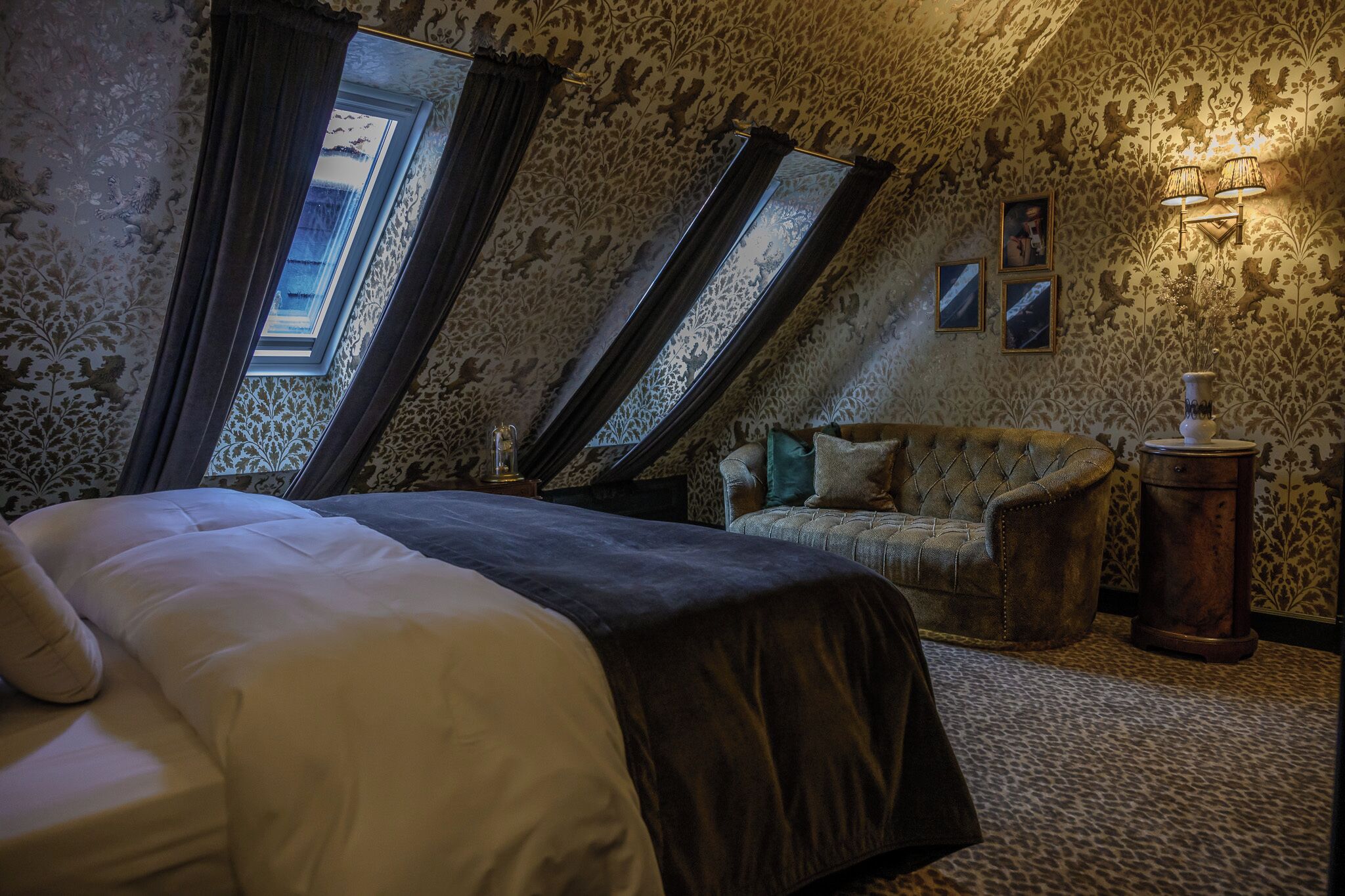 A bedroom with a bed, a chair, a lamp, and a window.