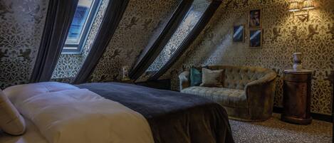 A bedroom with a bed, a chair, a lamp, and a window.