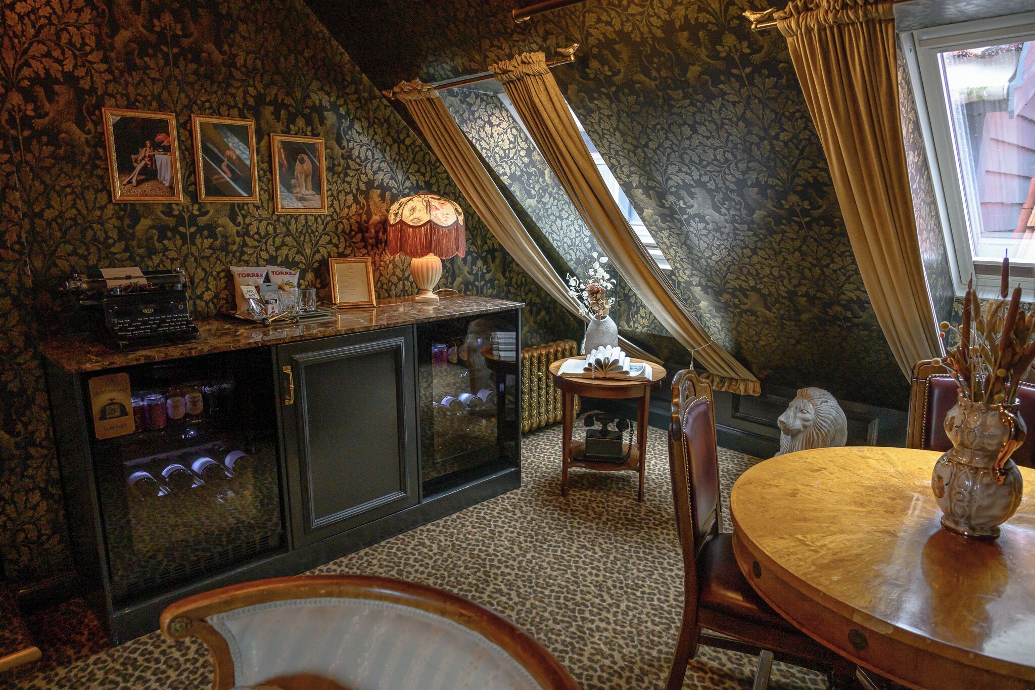 A cozy room with a wooden table, a vintage typewriter, and a decorative lamp.