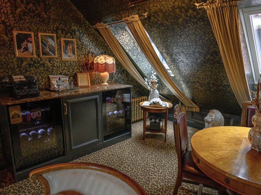 A cozy room with a wooden table, a vintage typewriter, and a decorative lamp.