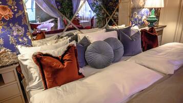 A neatly made bed with multiple pillows and a canopy.