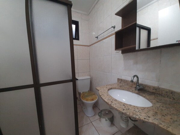 A bathroom with a toilet, sink, and a mirror.