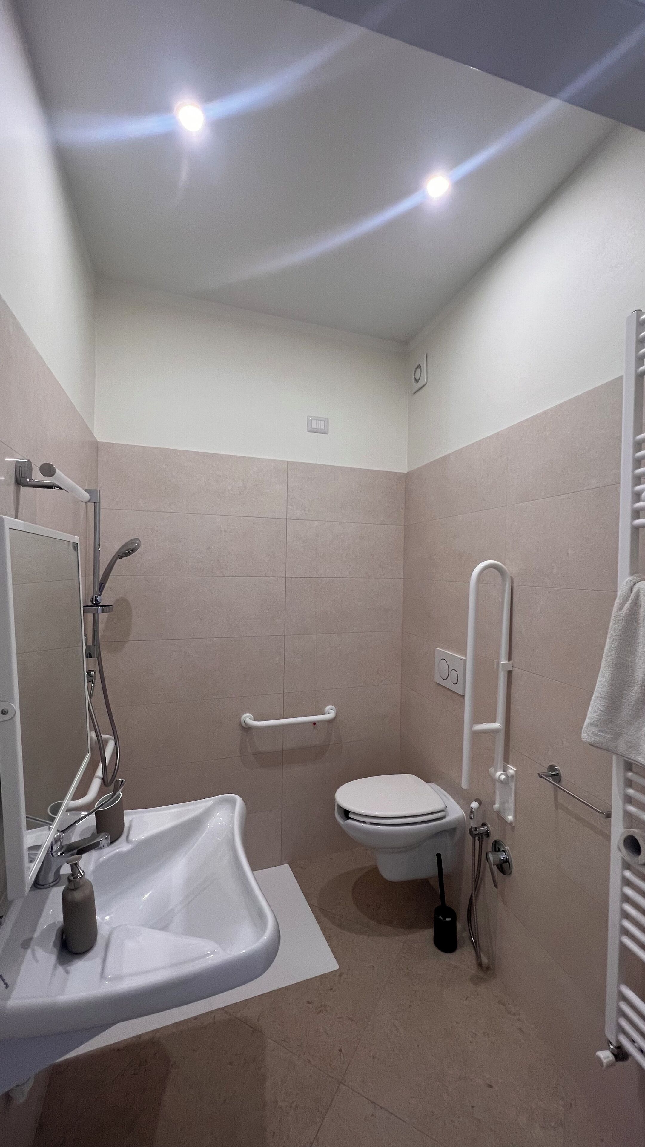 Un baño con lavamanos blanco, inodoro y zona de ducha.