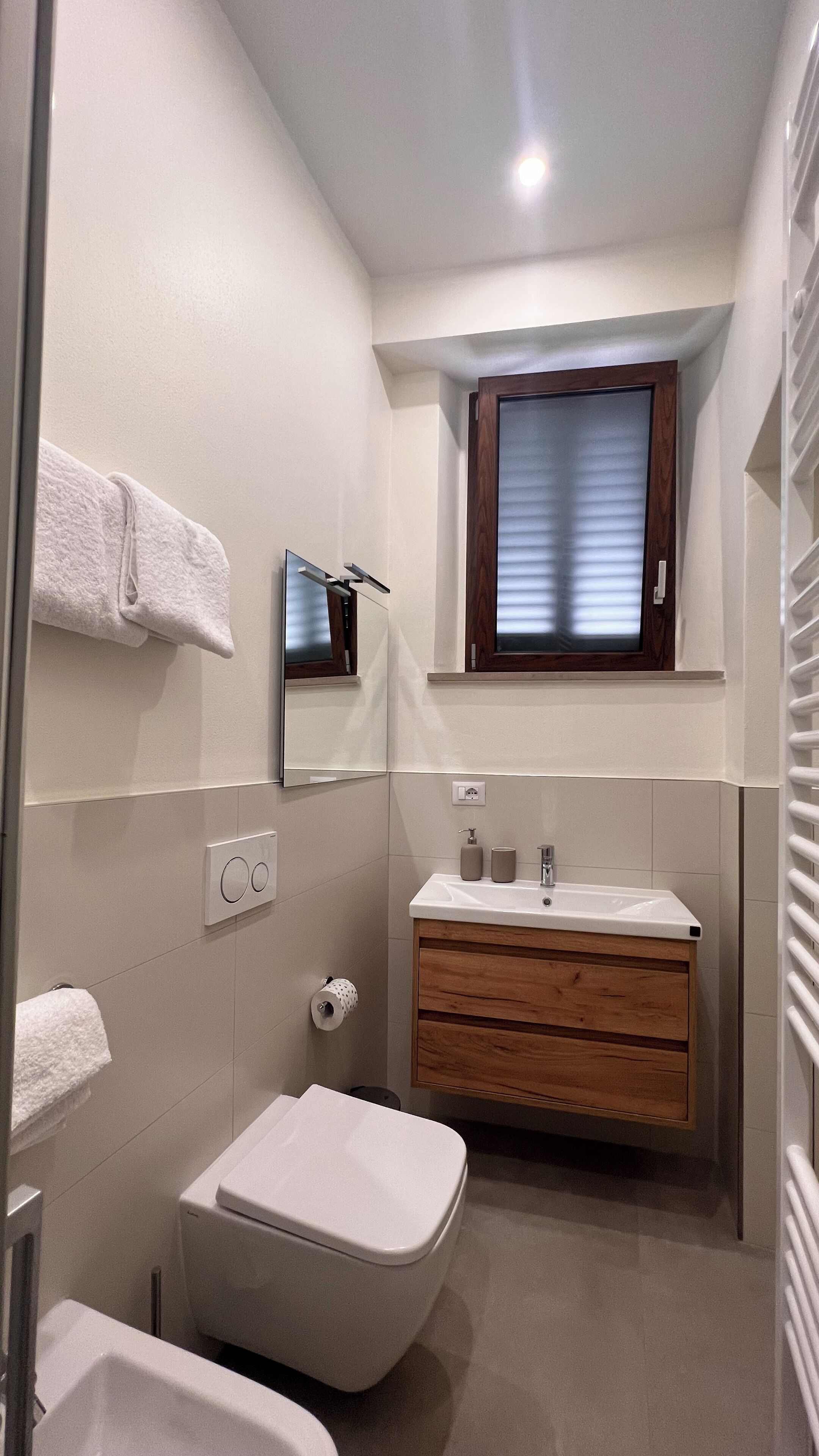 Un baño pequeño con inodoro, lavamanos y espejo.