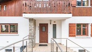 Een gebouw met twee verdiepingen, een stenen pilaar, een houten balkon en een houten deur.