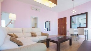 Una sala moderna con un sofá, una mesa de centro y una zona de comedor con sillas.
