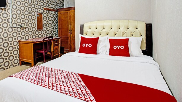 Une chambre d’hôtel avec un lit, un bureau et une chaise.