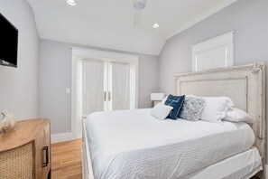 A bedroom with a bed, a wooden dresser, and a television on the wall. - Watercolor Resort |Private Pool | 6 Pass Golf Cart (Santa Rosa Beach)